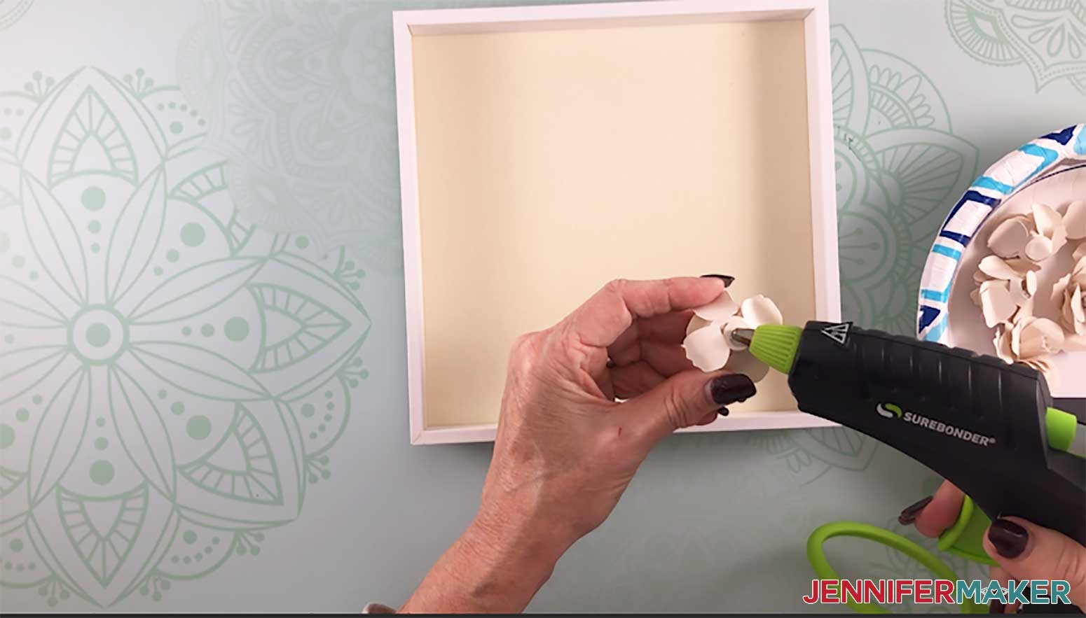 Gluing the paper flowers inside the shadow box