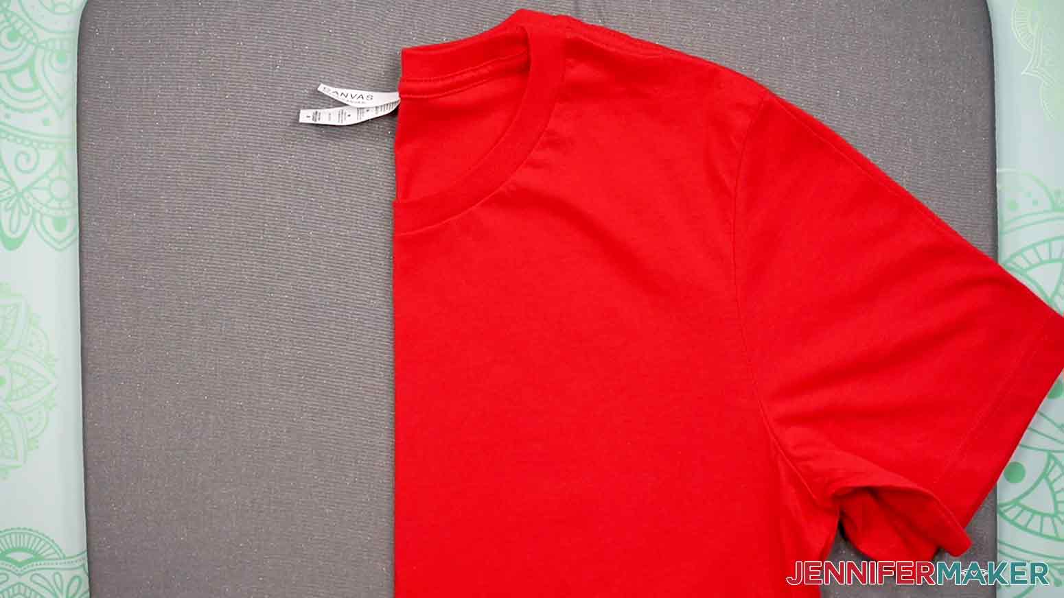 Fold your red, adult crew-neck T-shirt on the Cricut EasyPress Mat to create the center crease mark you will use to align the T-Shirt Ruler.