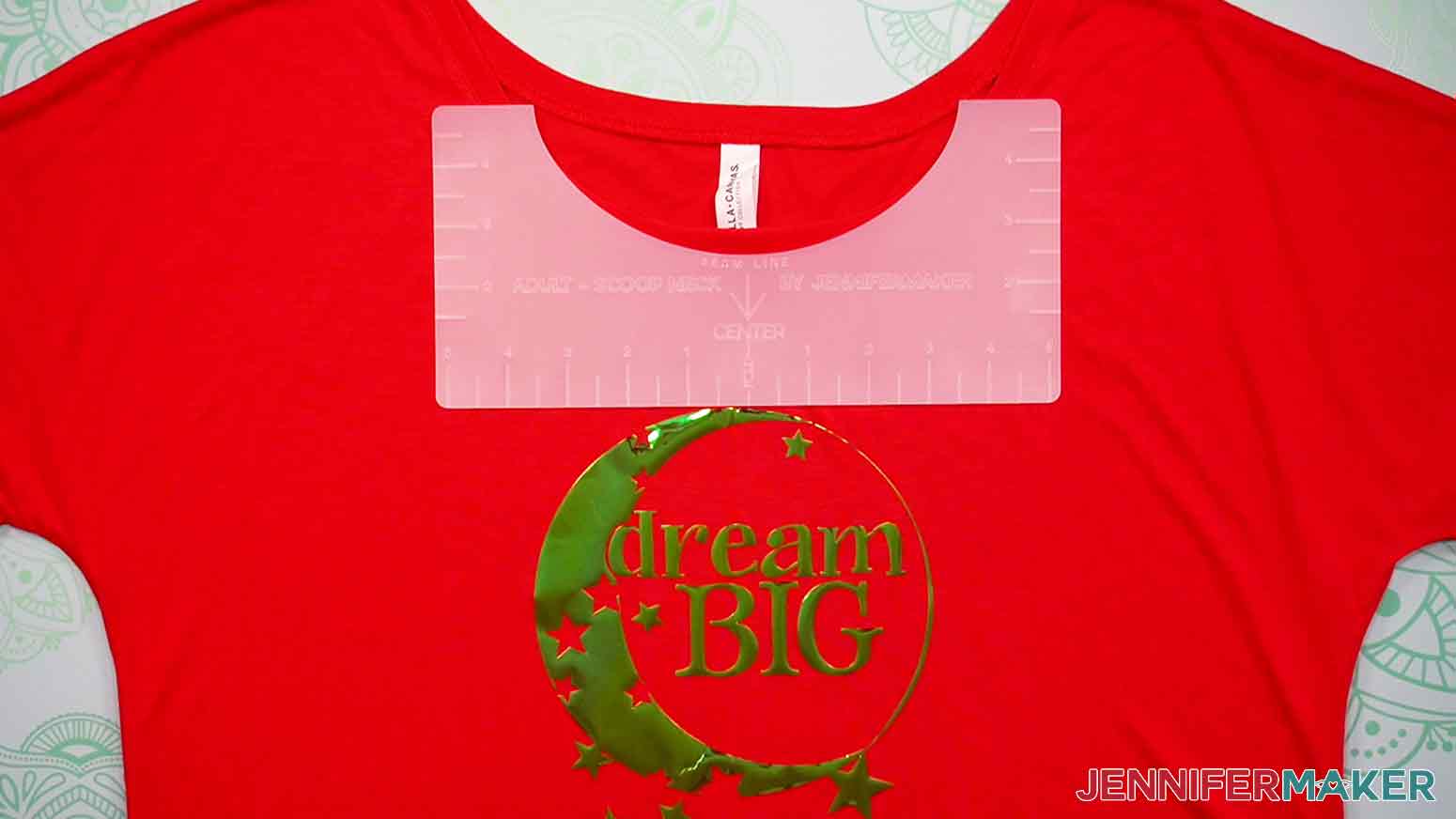 Here is an example of a red, adult scoop-neck T-shirt with the plastic Adult Scoop-Neck T-Shirt Ruler aligned under the neckline of the shirt, showing the proper placement and spacing of the Dream Big decal.