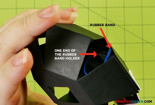 Place the rubber band in the head of the penguin paper bomb