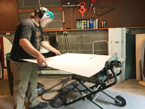 Cutting the white panelboard to size on the table saw