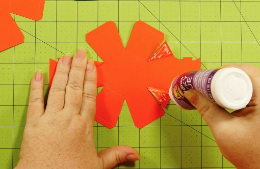Glue down the triangle sides on the pumpkin paper bomb
