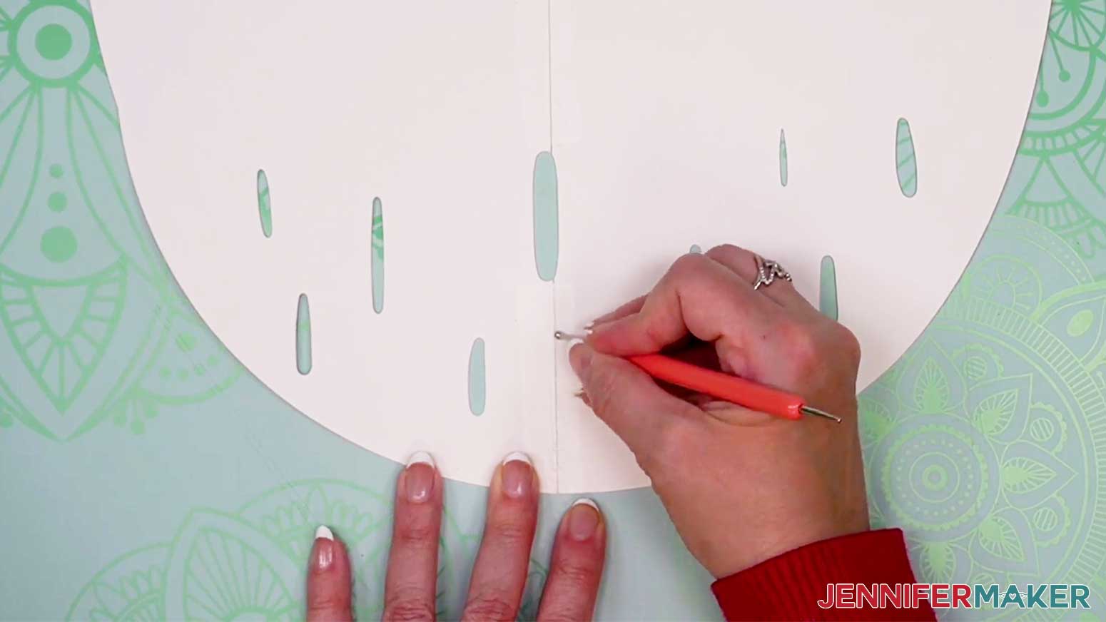Using a burnishing tool to burnish the seams of the cardstock for the DIY Cut Out Character.