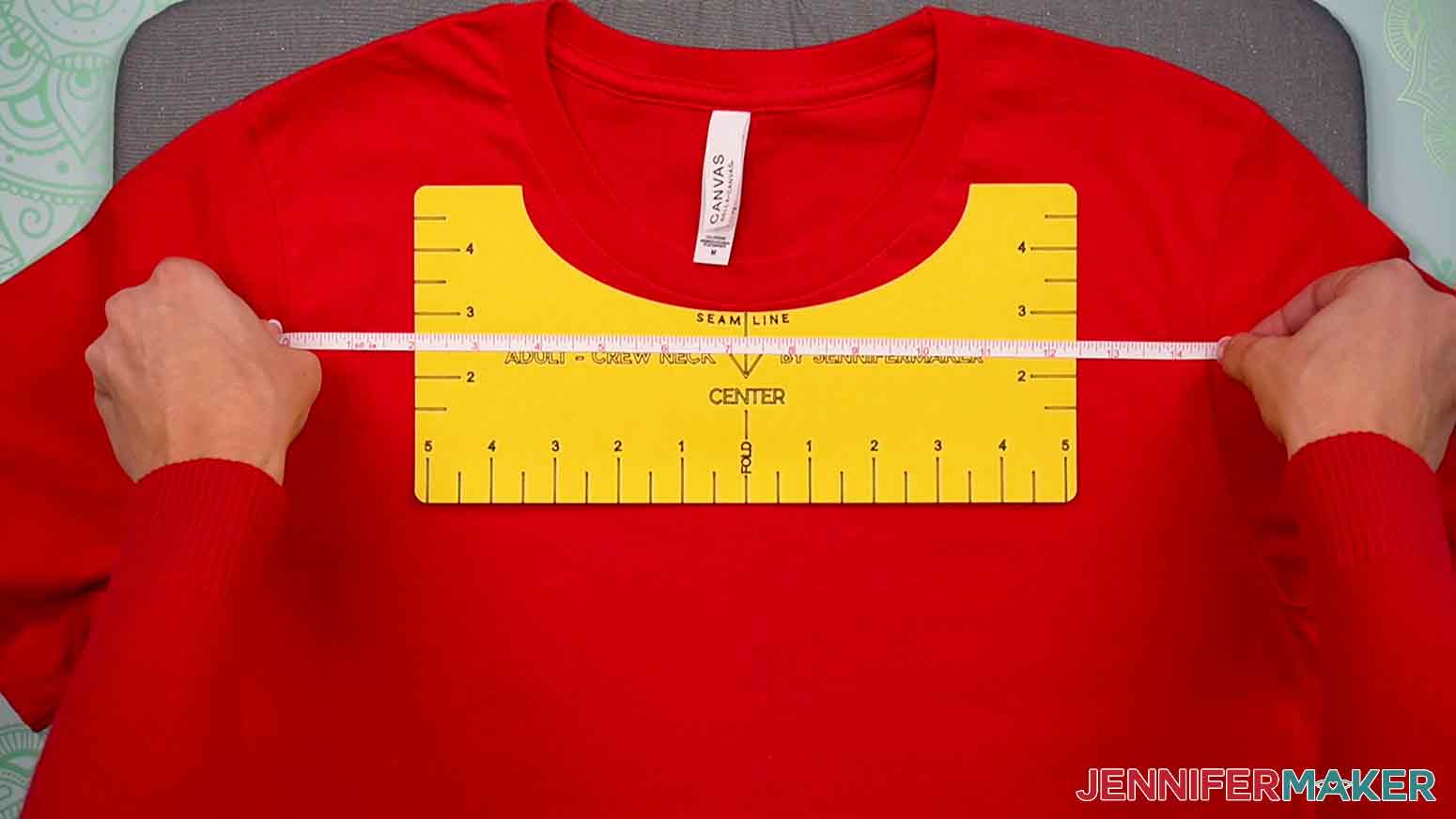 Use a measuring tape to measure the length between the t-shirt’s sleeve seam to ensure the T-Shirt Ruler is centered on the front of the shirt.