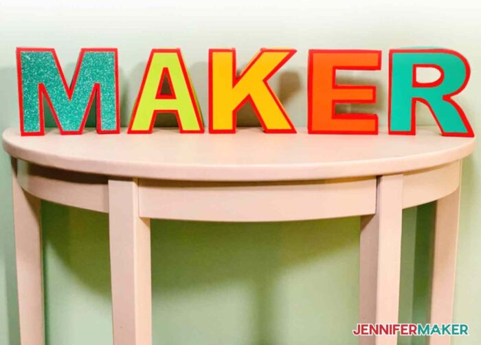 Decorative 3D Paper Letters on a wooden table spelling MAKER