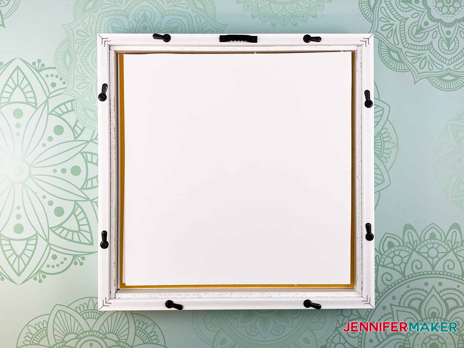 Add foam core to the back of the picture frame to prevent the stacked layers from moving