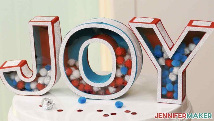 3d letters that spell "JOY" in blue and red cardstock with shaker windows