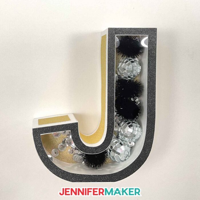 A 3D letter J with a clear window to show pom poms in the shaker area.