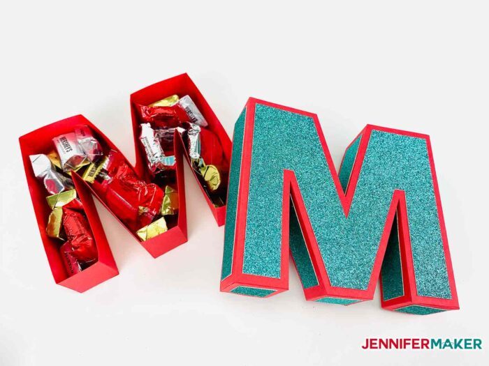 The letter M made from red and blue cardstock and turned into a gift box filled with chocolate