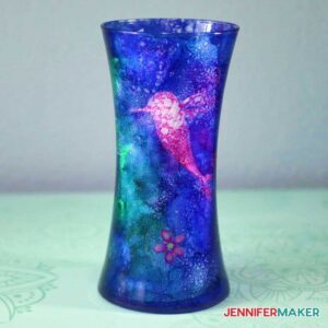 Blue and pink alcohol ink on glass to design a blue glass vase with pink flowers