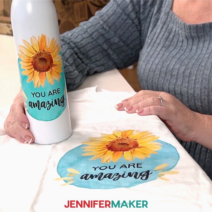 Jennifer shows off two Canva gifts: a water bottle and a T-shirt with a sunflower design and the words "You are amazing."