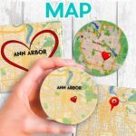 Make a custom ceramic tile map with sublimation with Jennifer Maker's tutorial! Image description: Three ceramic tile maps sit on a white wood surface, with one held close to the camera to show detail. Maps are of Ann Arbor, Michigan, and feature cute heart icons you can add in Cricut Design Space.