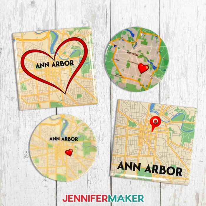 Make a custom ceramic tile map with sublimation with Jennifer Maker's tutorial! Image description: Four ceramic tile maps sit on a white wood surface. Maps are of Ann Arbor, Michigan, and feature cute heart icons you can add in Cricut Design Space.