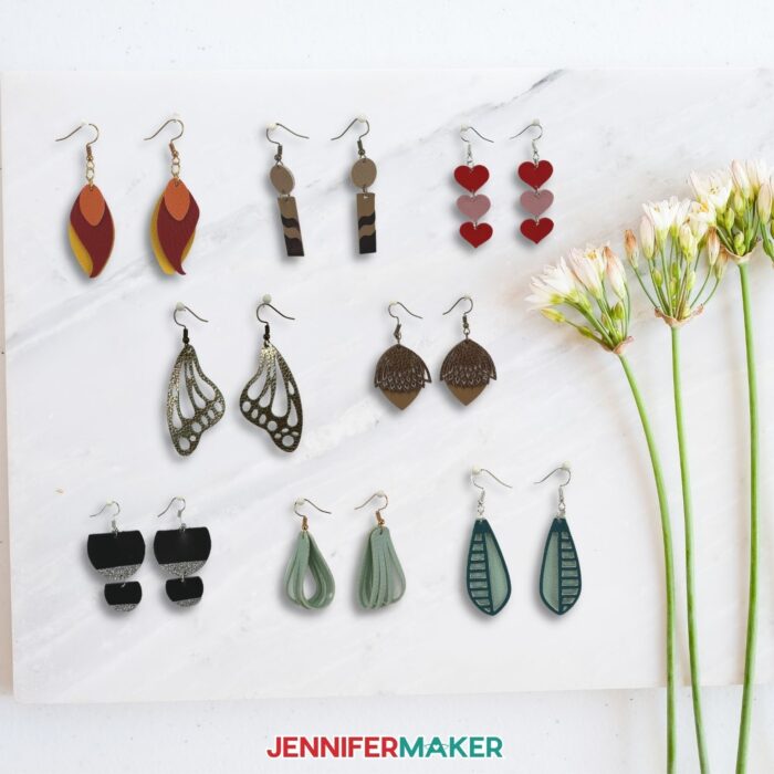 Eight pairs of DIY faux leather earrings with a few flowers beside them