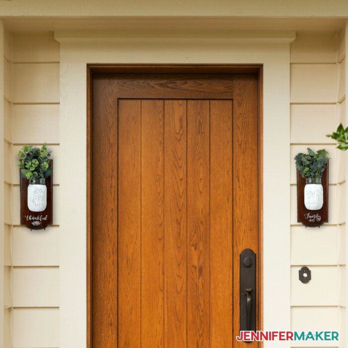 DIY mason jar wall decor on the exterior of a house beside the door