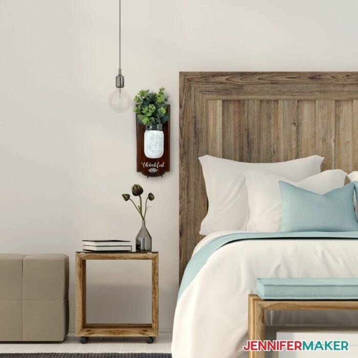 DIY mason jar wall decor beside a bed and above a night stand