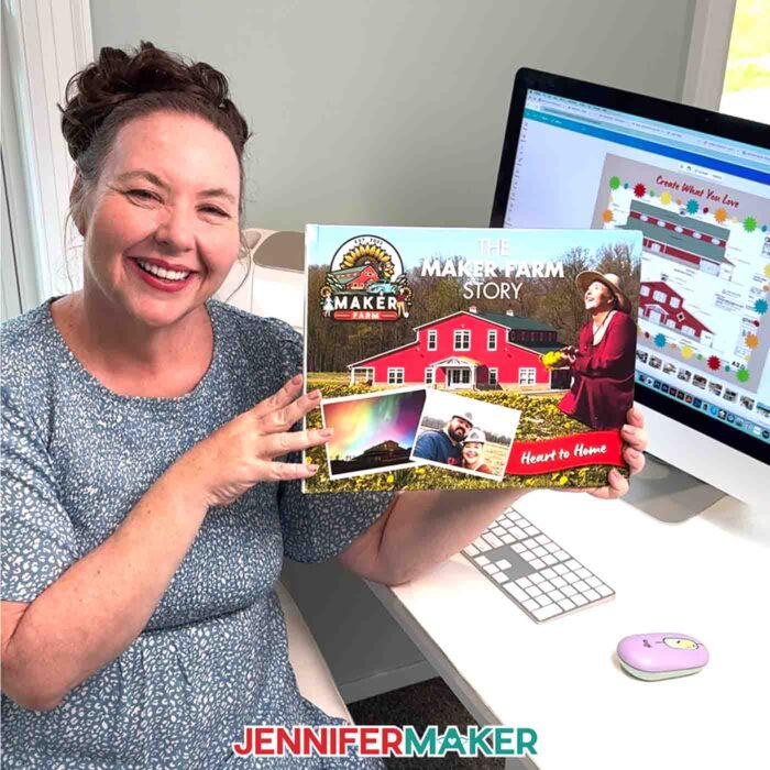 Jennifer Maker sits at her computer desk and holds her DIY Photo Book she created with Canva