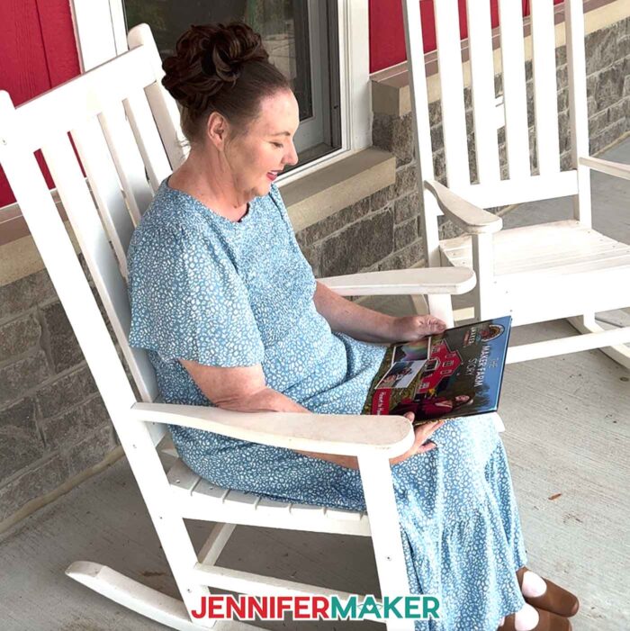 Jennifer Maker sits on her porch at Maker Farm and looks at an her DIY Photo Book she created with Canva