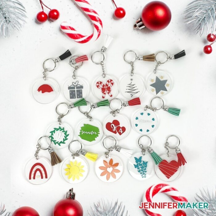 Acrylic Keychains with vinyl designs placed on a white surface with festive decor