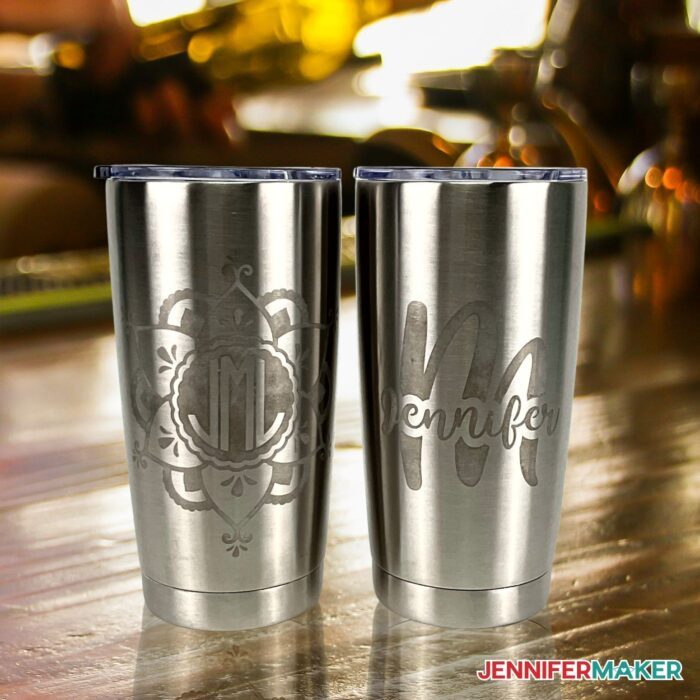 Two DIY Etched Stainless Steel Tumblers on wooden surface