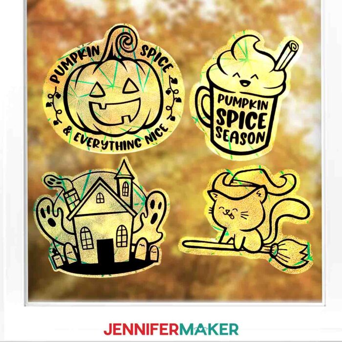 Learn how to make Fall Window Suncatchers with JenniferMaker's tutorial! A window looking out onto fall leaves is decorated by crafted rainbow window clings with vinyl decals in various fall and Halloween designs.
