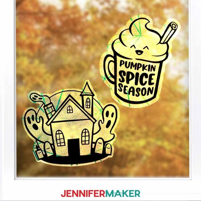 Learn how to make Fall Window Suncatchers with JenniferMaker's tutorial! A window looking out onto fall leaves is decorated by crafted rainbow window clings with vinyl decals in various fall and Halloween designs.