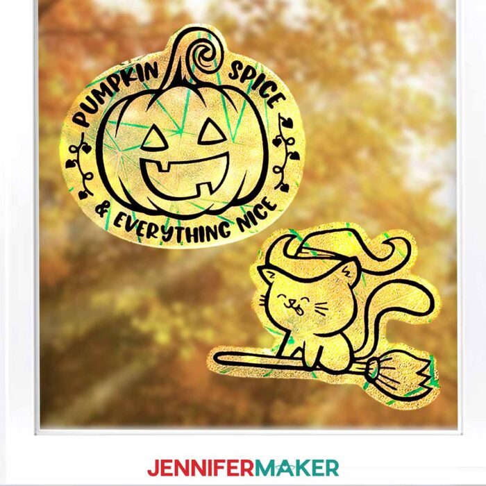 Learn how to make Fall Window Suncatchers with JenniferMaker's tutorial! A window looking out onto fall leaves is decorated by crafted rainbow window clings with vinyl decals in Halloween designs.