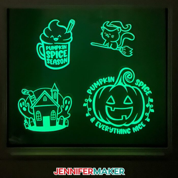 Learn how to make Fall Window Suncatchers with JenniferMaker's tutorial! A dark window is decorated by crafted window clings with glow-in-the-dark vinyl decals in various fall and Halloween designs.
