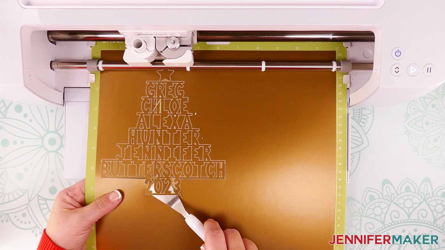 Use a spatula to check the cut of the poster board for the personalized family name tree ornament.