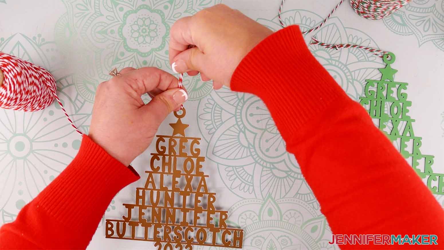 Attach a piece of ribbon or twine to the hanger of the family name ornament.