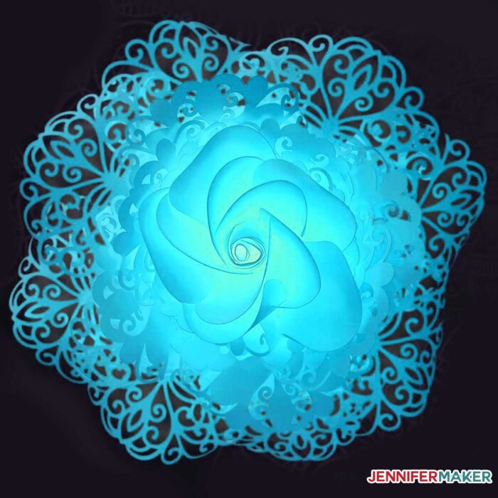 Pretty teal blue lace paper flower on a black background