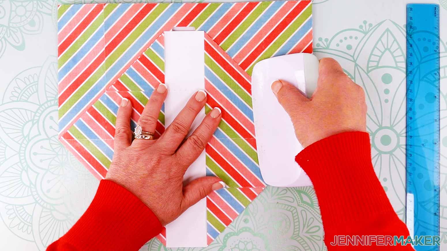 Use a scraper to crease the side triangle folds in the gift bag.