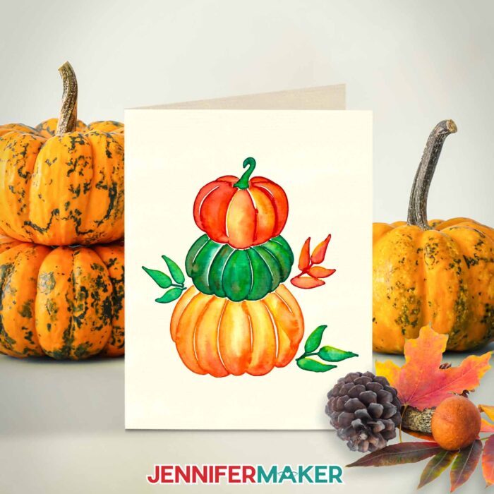 Halloween watercolor design of a stack of orange and green pumpkins.