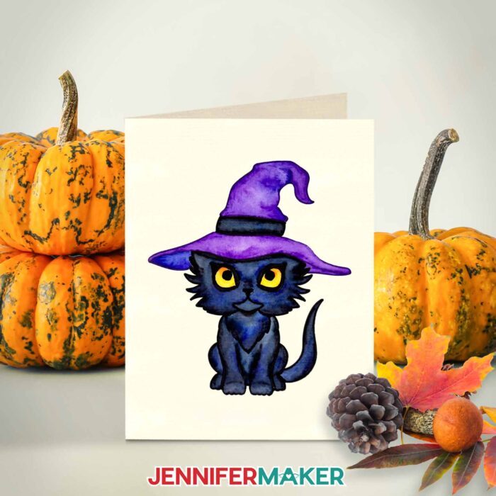 Halloween watercolor design of a black cat wearing a witch hat.