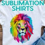 Not sure how long to heat press a sublimation shirt? Find out how with JenniferMaker's tutorial! A white T-shirt with Jennifer's multicolored sublimation lion design on the front lies on a wooden background with a pair of distressed blue jeans folded nearby.