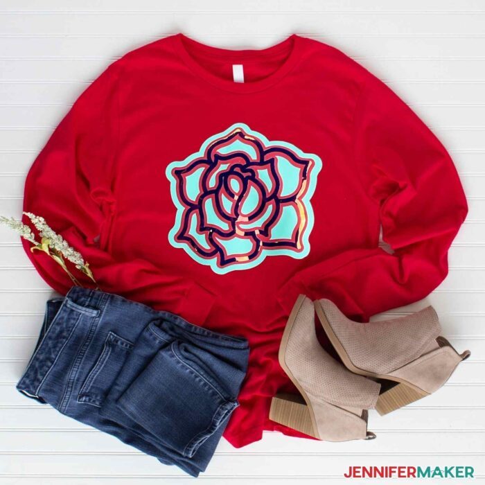 Red T-shirt with layered iron-on vinyl decal of a flower with holographic vinyl to show how to layer vinyl on a shirt