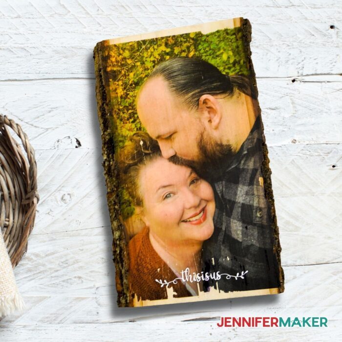 Photo of a man kissing a woman on the forehead transferred to wood on a white background