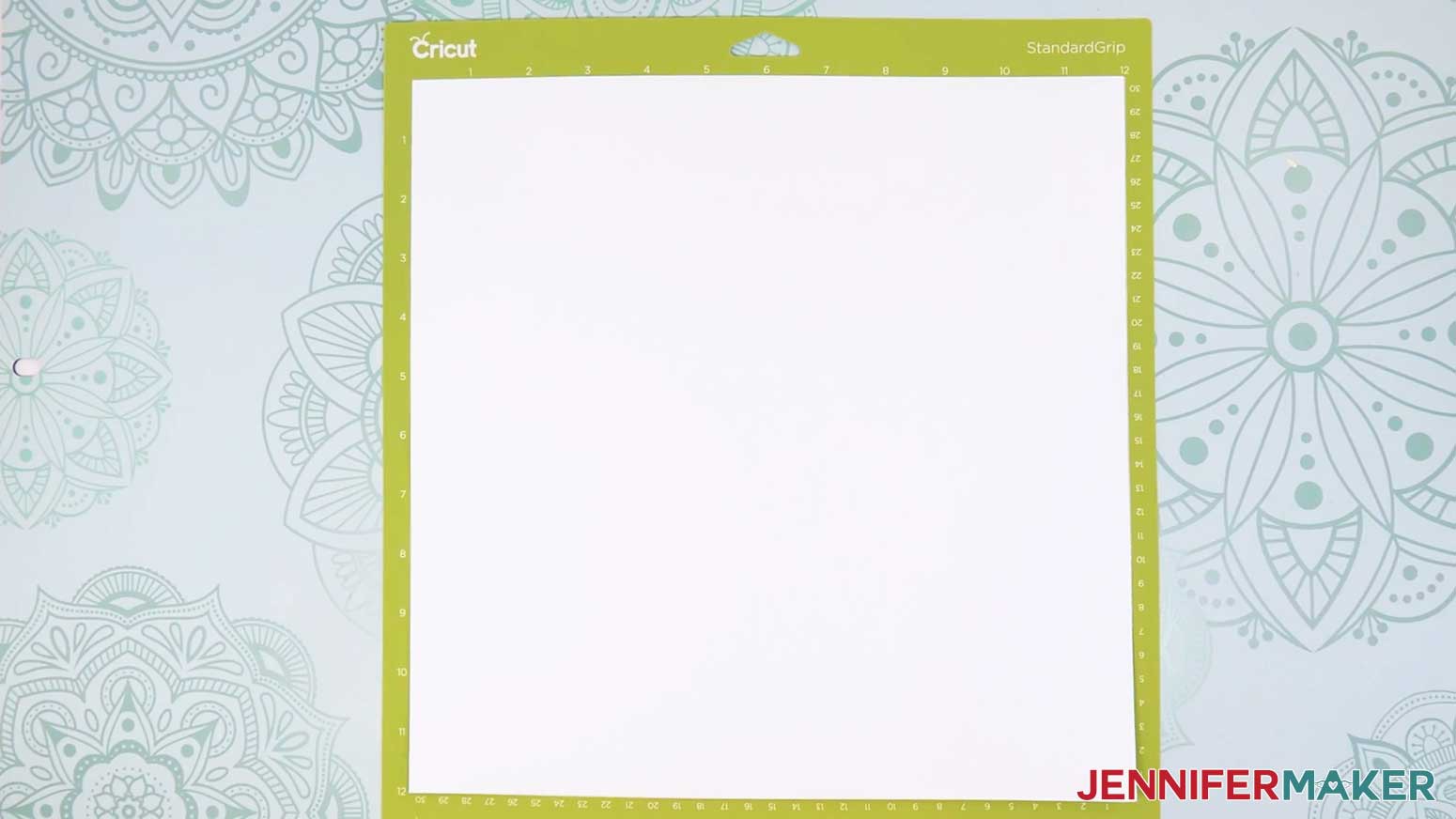 Place a piece of 12" x 12" white cardstock on a green machine mat.