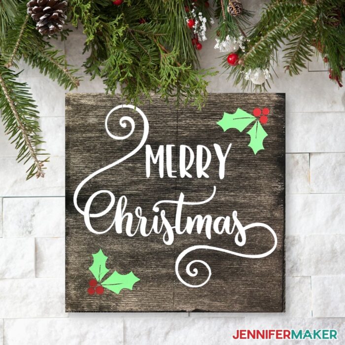 Wooden board with the words "Merry Christmas" on it made using a reusable Stencil made with a Cricut cutting machine