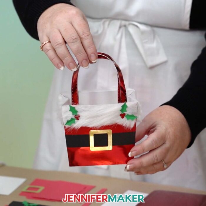A small gift bag made to look like Santa's red belly with a fluffy top and belt detail.