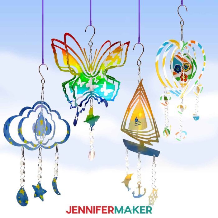 Four sublimated wind spinners: a cloud with stars, a butterfly with rainbow colors, a heart with flowers, and a sailboat with a sunset scene. Designs by JenniferMaker.