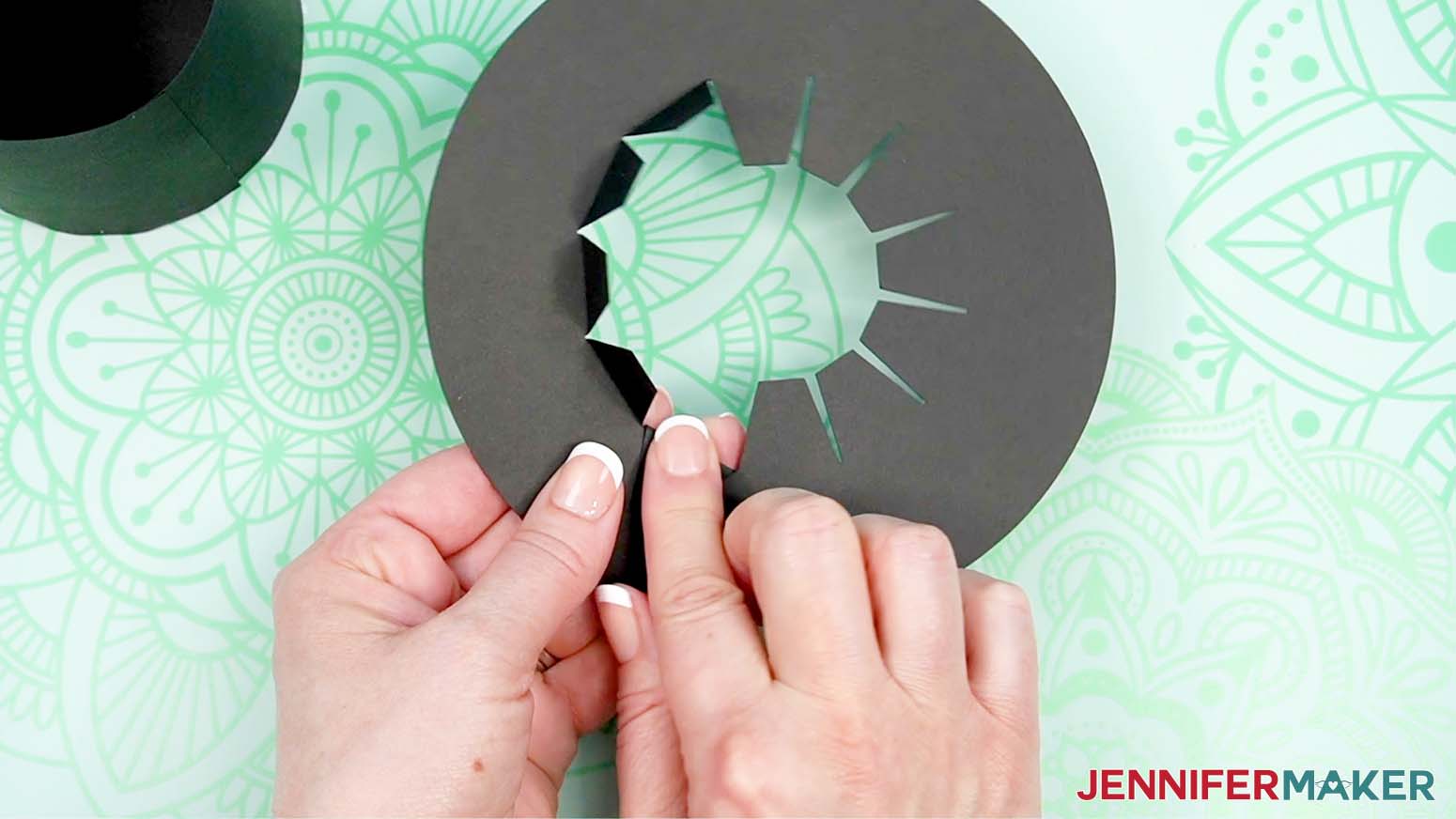 Fold the tabs around the center of the brim upward.
