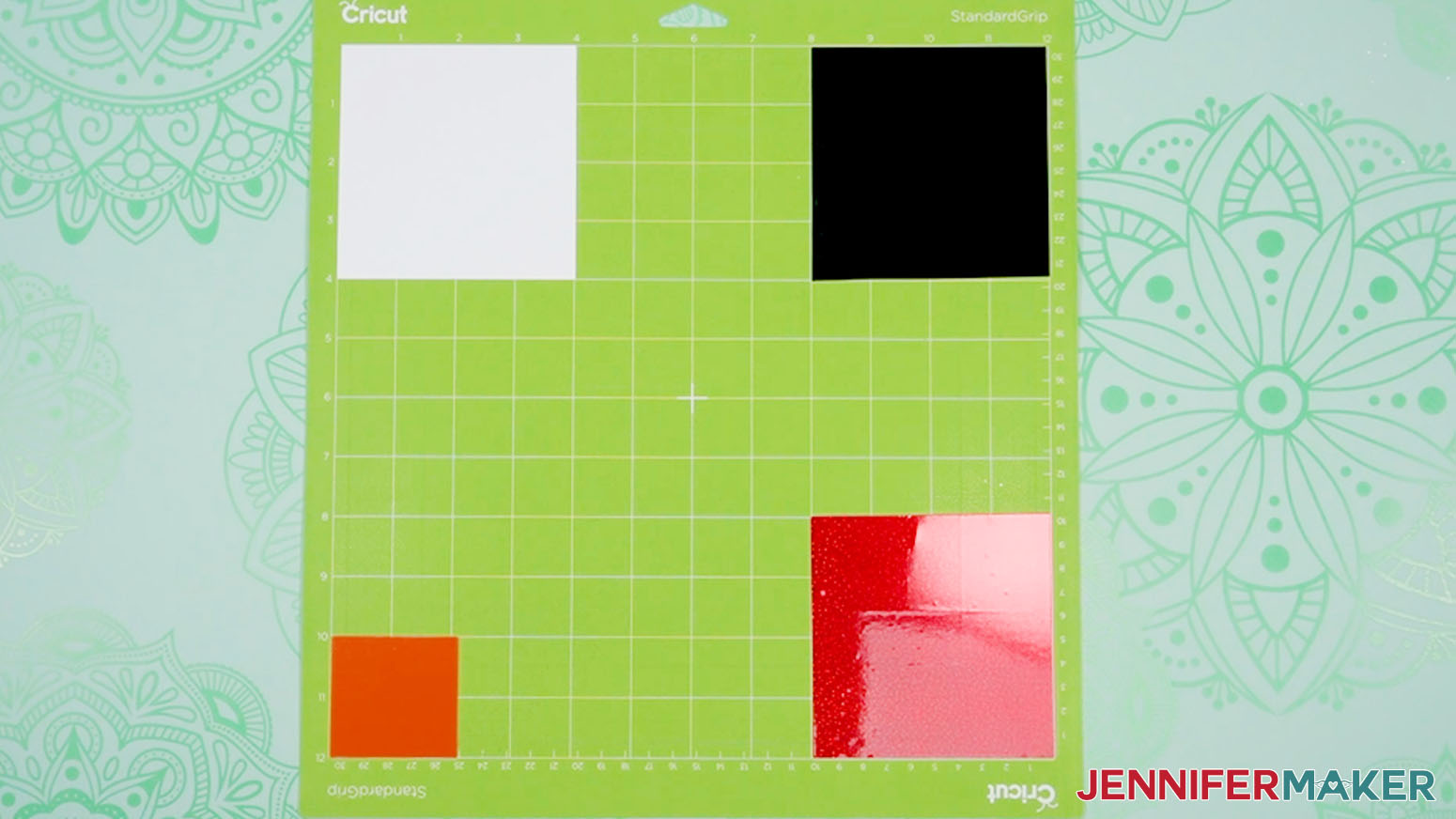 White, black, orange, and red vinyl pieces in their respective four corners of the machine mat.