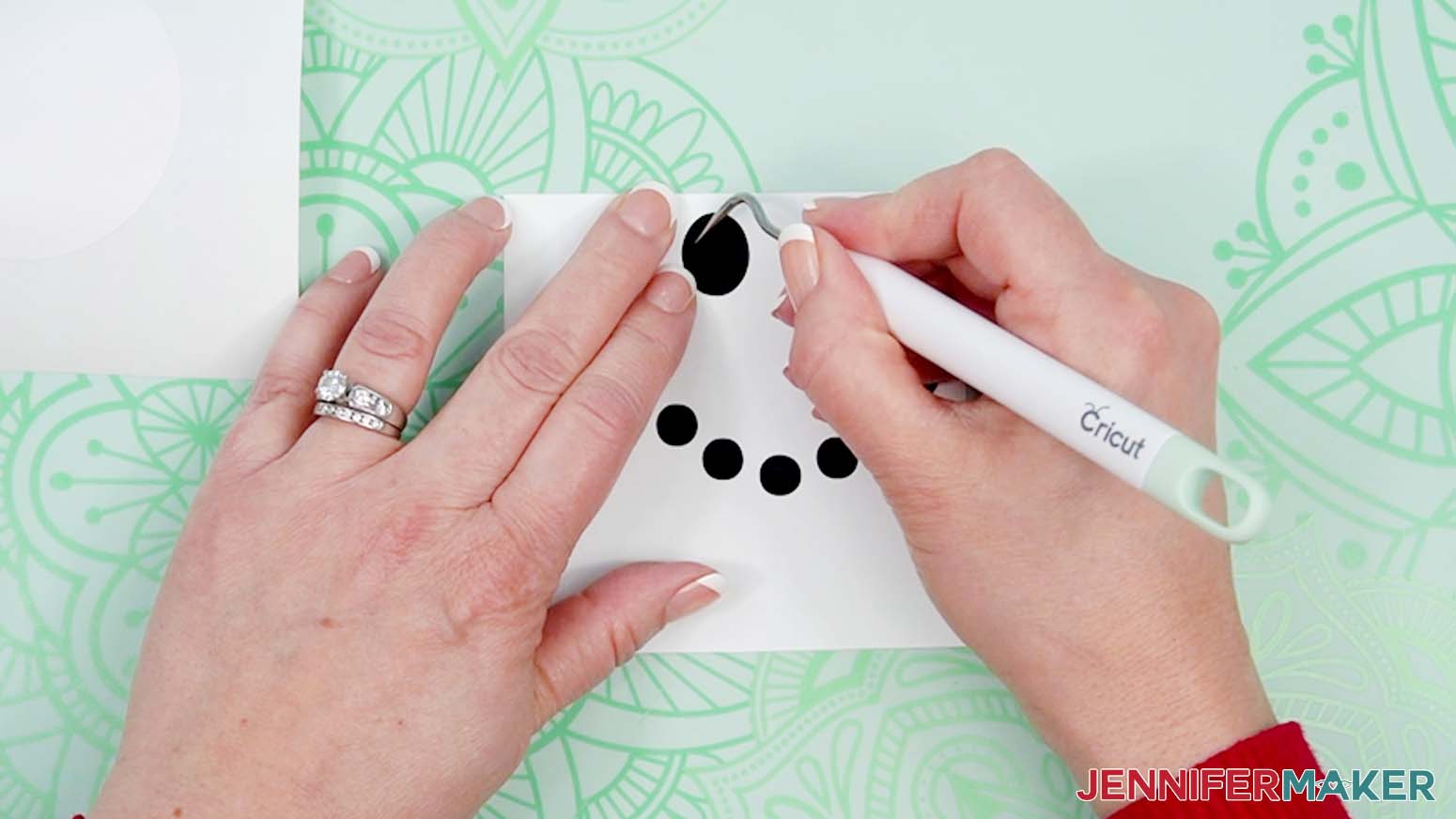 Use a weeding tool to remove excess vinyl around the cut design pieces.