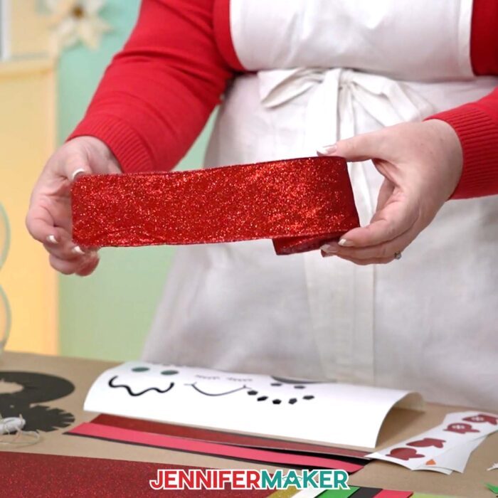 Jennifer shows a length of wide red ribbon used to embellish a Snowman With Belly Scene craft