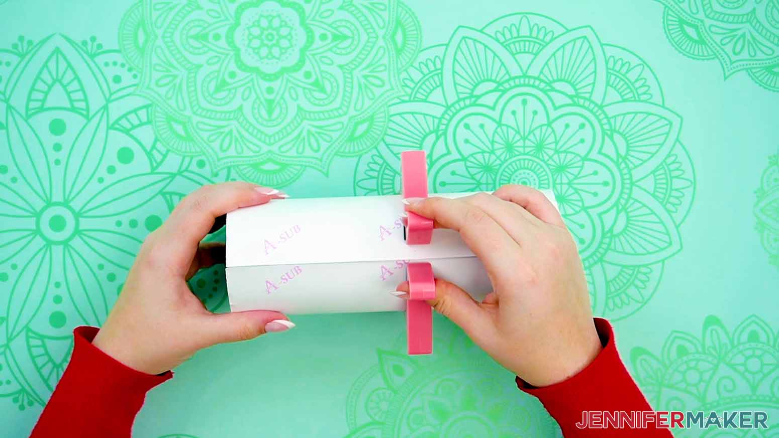 Close a pinch tool over the center of the wrap and tumbler making sure to keep the seam straight.