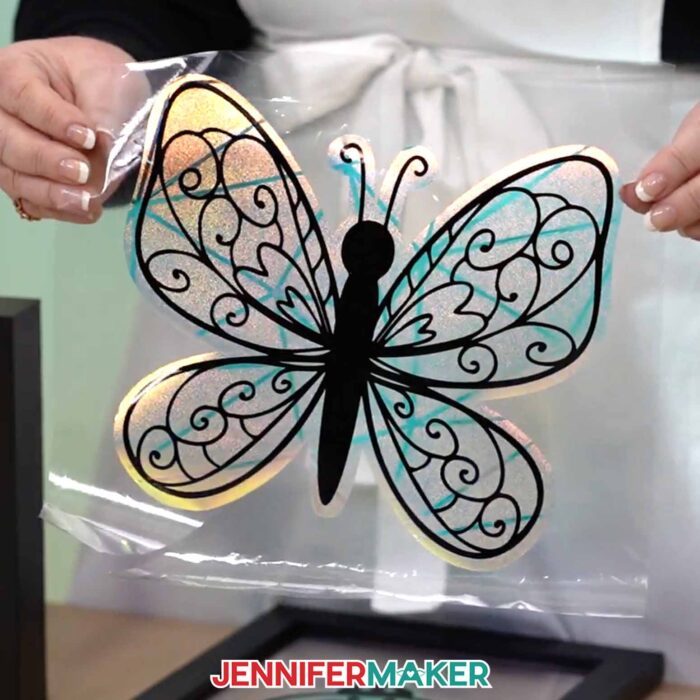 Jennifer holds up a butterfly suncatcher window cling. Learn how to make your own window clings in this tutorial!
