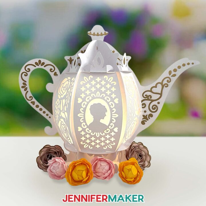 The assembled teapot lantern with crepe paper flower embellishments displayed in front.