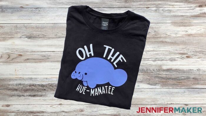 Black t-shirt with "Oh The Hue-Manatee" design turned dark and light blue in the sunlight. Learn to use color changing HTV with JenniferMaker's tutorial!