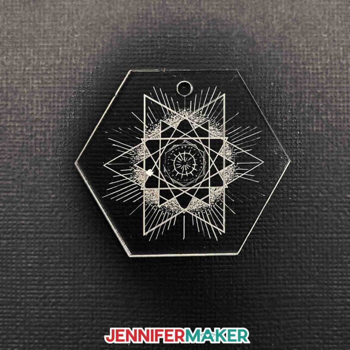 A hexagon acrylic engraved keychain with a geometric star design.